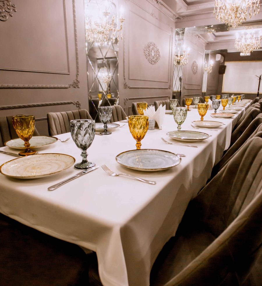 restaurant dinner table with plates cutlery yellow and blue glasses